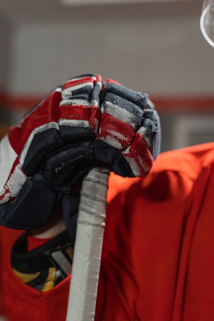 Vibrant close-up of a hockey glove gripping a stick, showcasing sports gear.